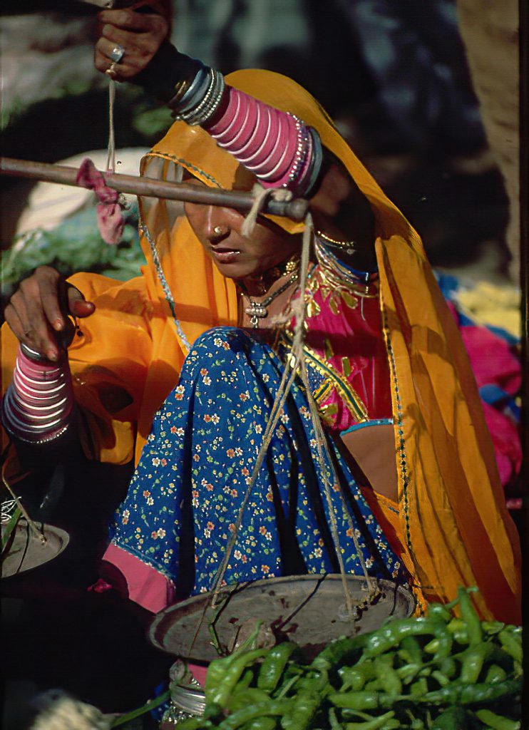 UDAIPUR, INDIA - OCT 24, 1988 - Rajasthani woman weighing vegetables in market,Udaipur, India , Asia